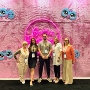 An image of five people stood in a line smiling.