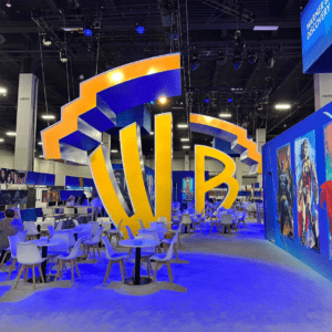 An image of a number of tables and chairs in front of a large Warner Brothers logo.