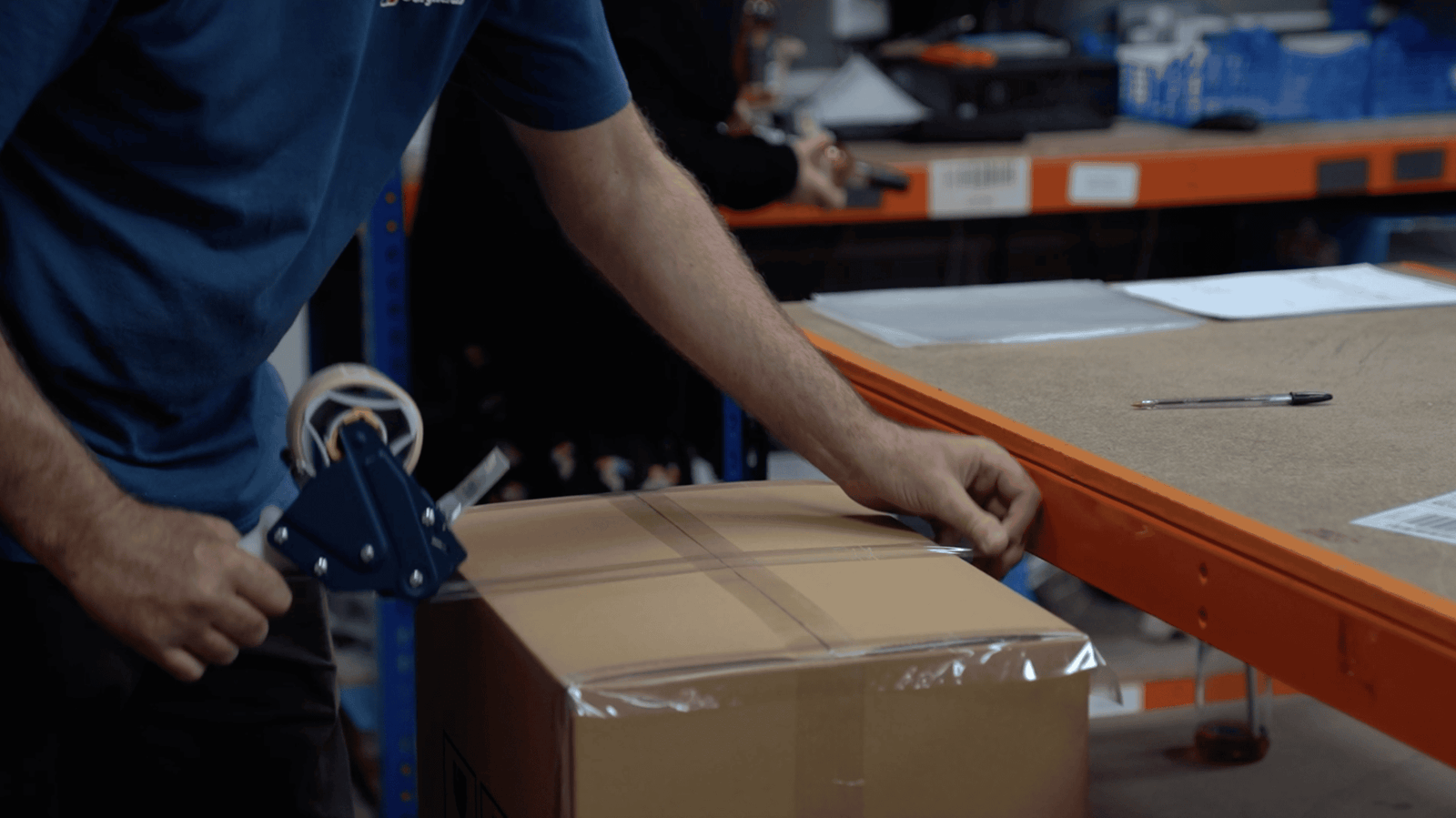 Hands taping a box shut.