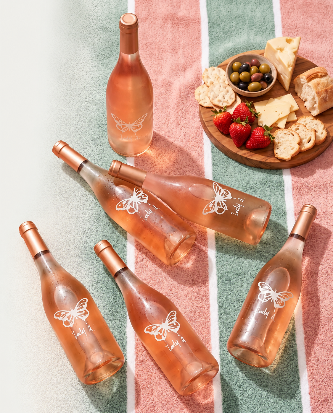 Bottles of Lady A wine on a striped blanket with a cheeseboard.